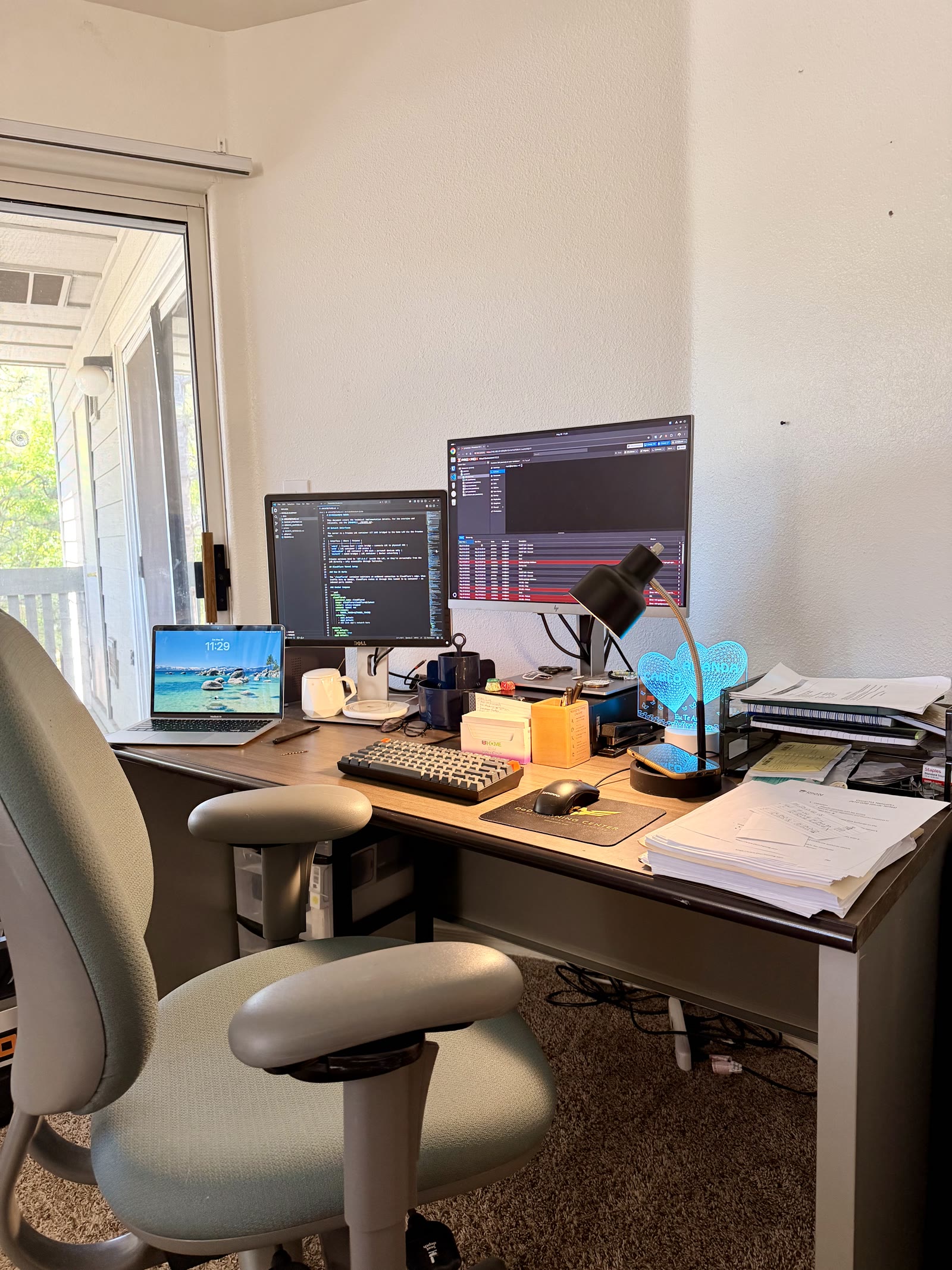 Desk setup with Proxmox open on one monitor and infrastructure notes on another